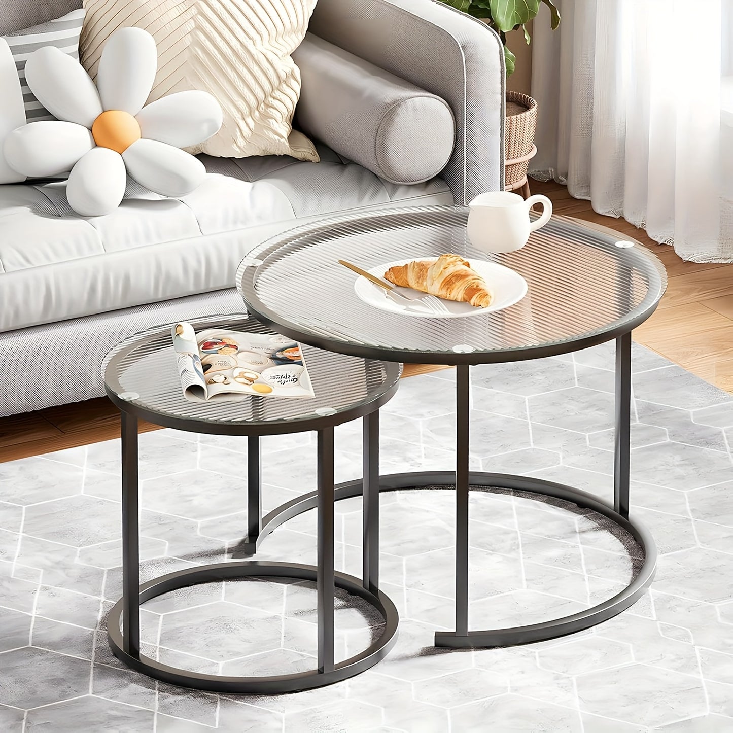 Set of Two Nesting Glass Coffee Tables, Featuring Small Round Designs Suitable for Living Rooms Or Bedrooms, with a Modern Industrial Style And a Black Metal Frame.